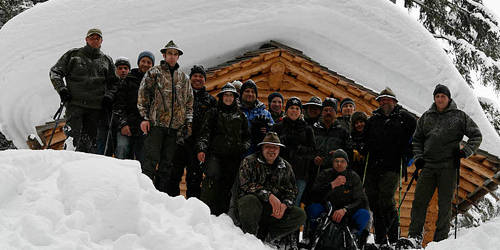 Teilnehmergruppe Jagdkurs vor einer Jagdhütte im Winter