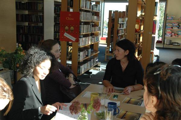 Teilnehmer unterhalten sich bei einem Tisch im Sprachzentrum
